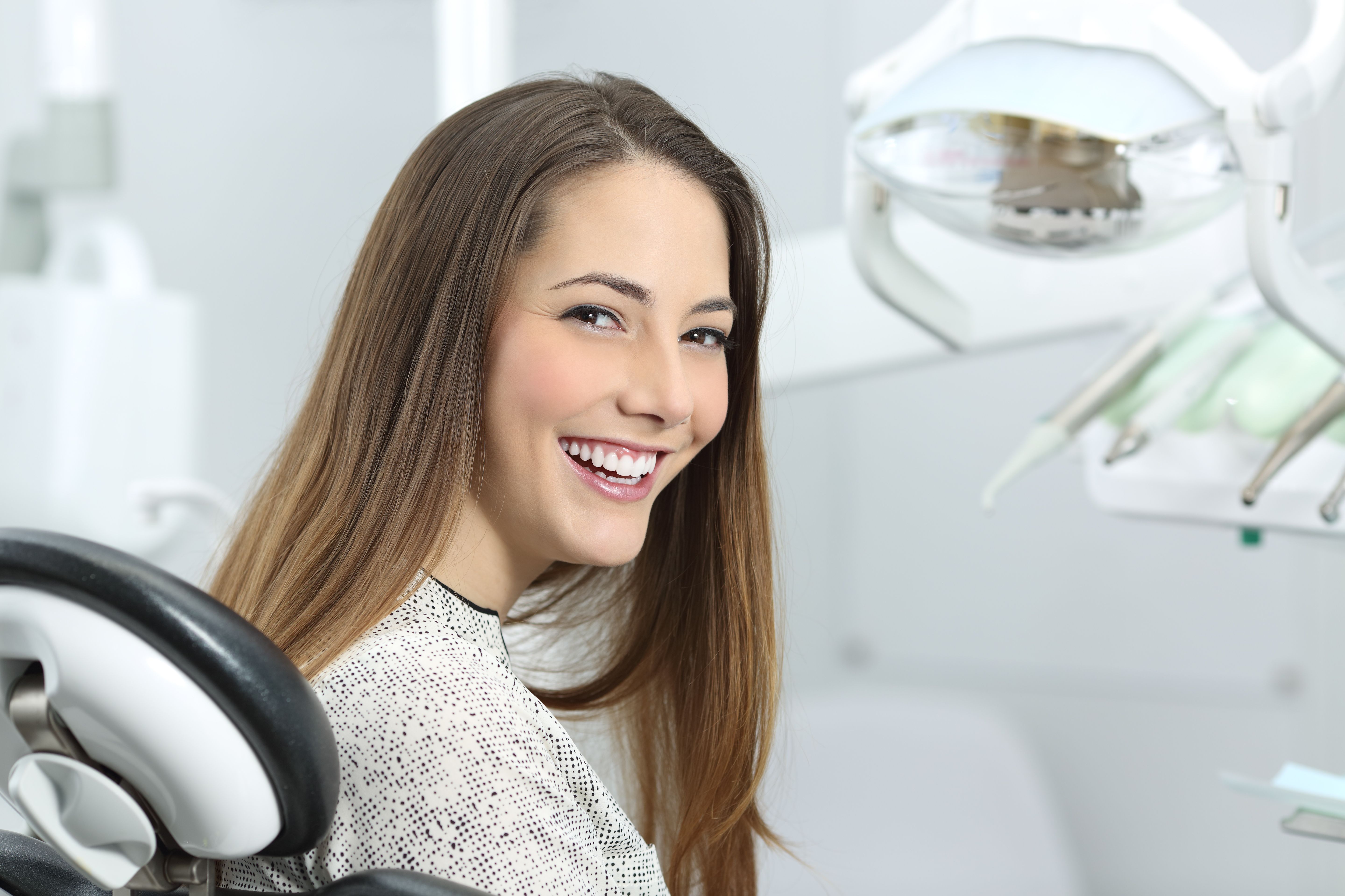 A young woman smiling prior to her dental examination.